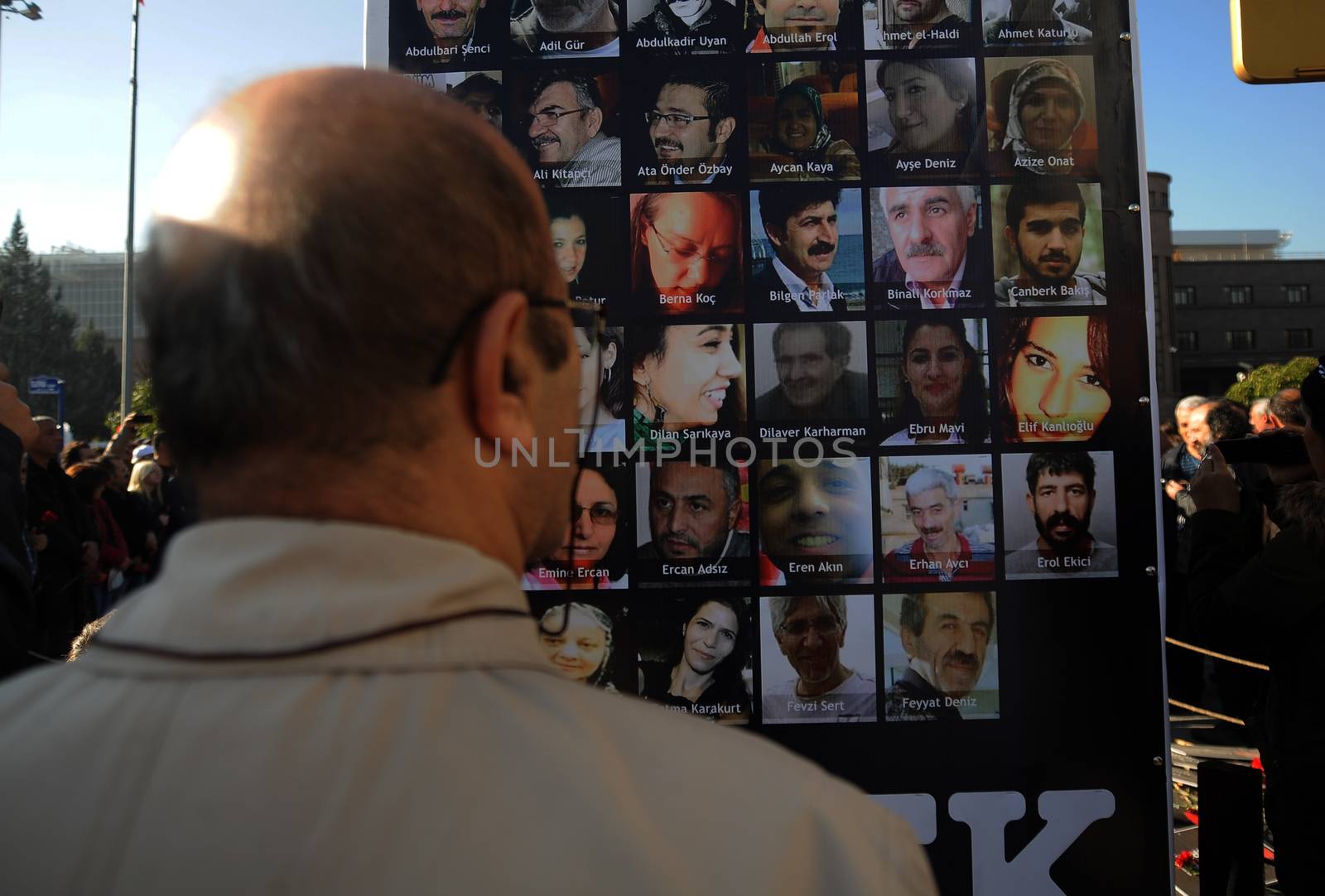 TURKEY, Ankara: A man looks upon a sign bearing the faces of victims of the October 10 bombings during a ceremony in Ankara, Turkey on November 7, 2015, honoring the victims. The twin explosions left at least 97 people dead and more than 400 others injured on October 10.