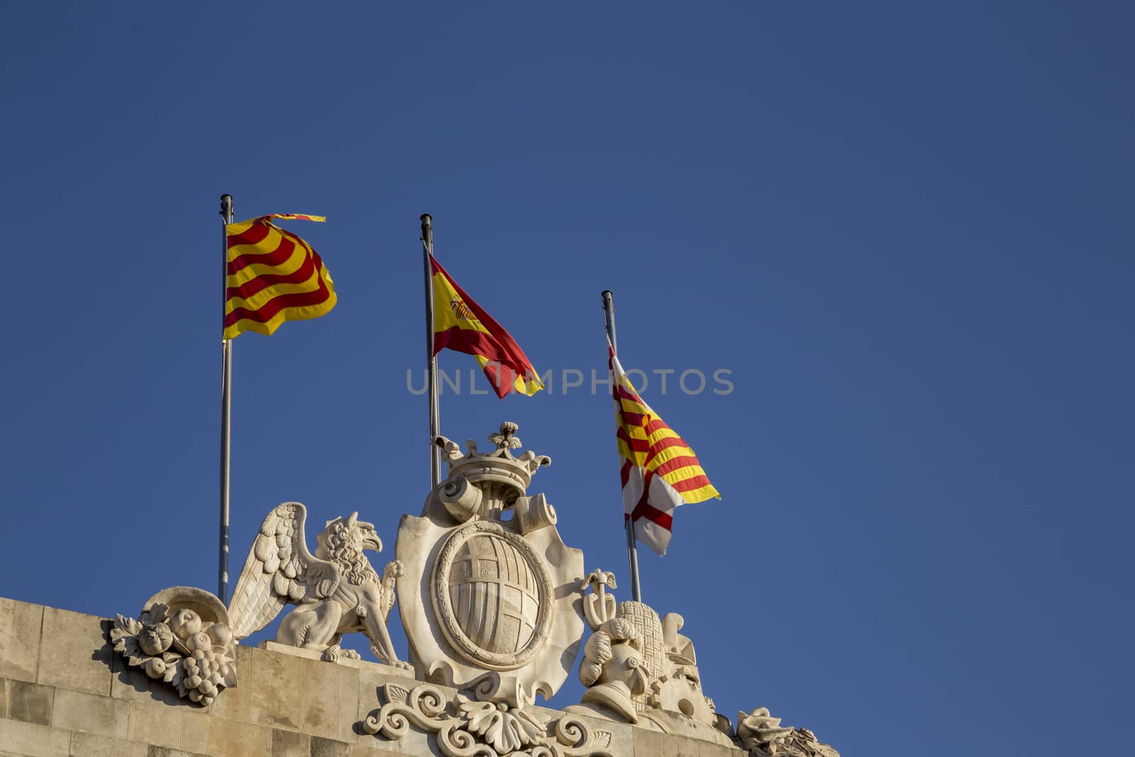 Patriotic Catalan Flags flying on top of Casa de la Ciutat, Barcelona, Spain