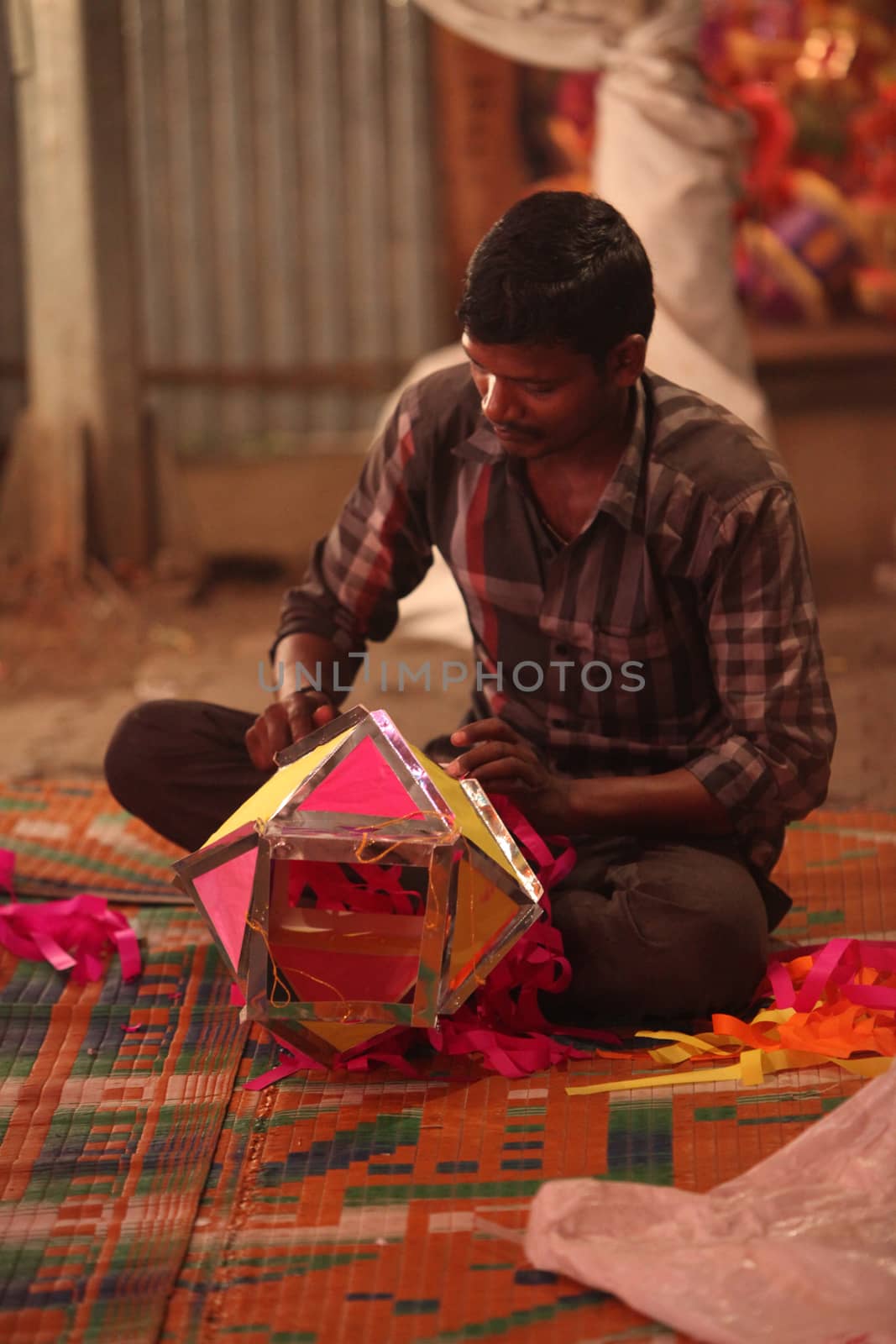 Pune, India - November 7, 2015: A man making a traditional sky lantern in his shop on the occasion of Diwali festival in India
