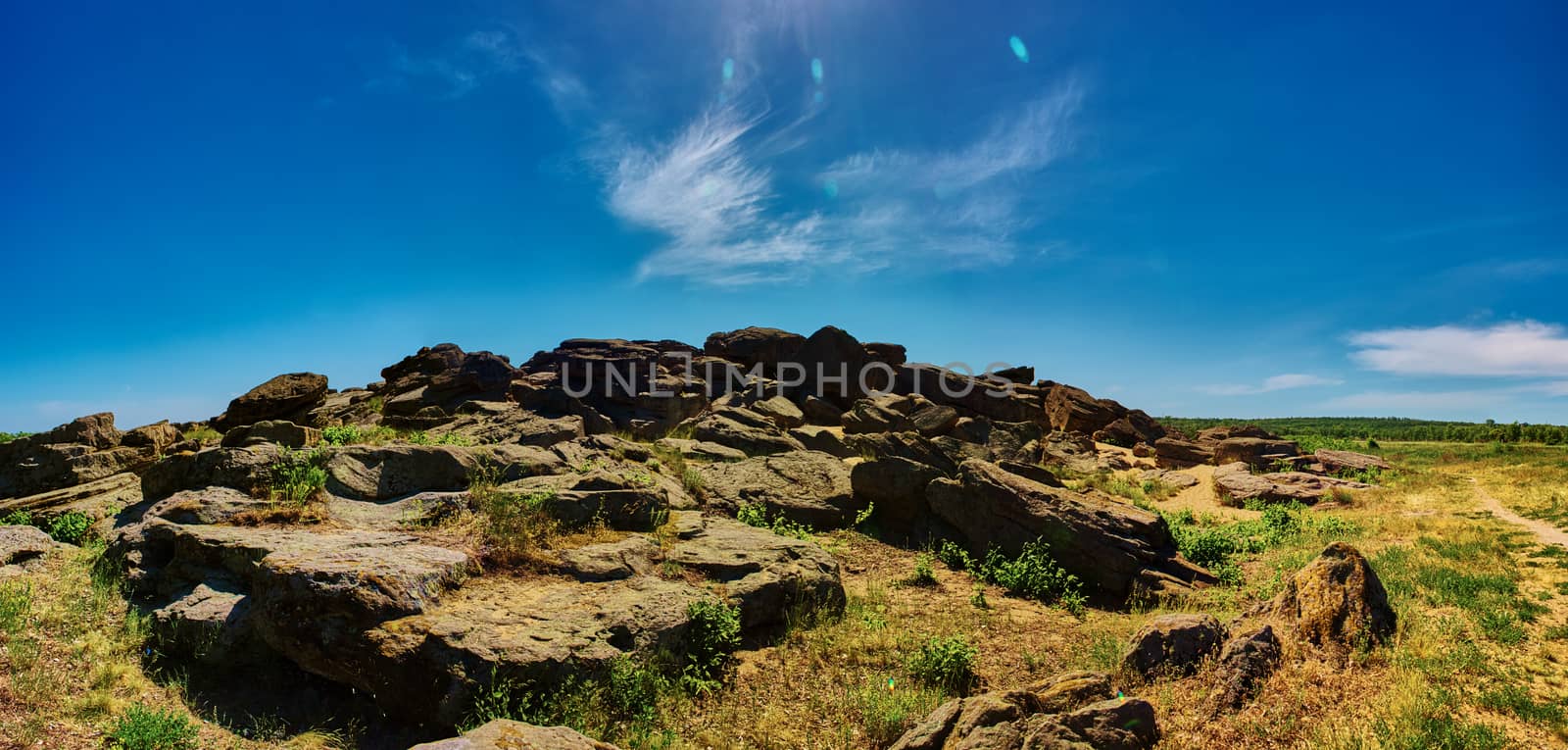 Stone range Kamyana Mohyla. The site encompasses a group of isolated blocks of sandstone, up to twelve meters in height, scattered around an area of some 3,000 square meters. As Noghai legend has it, it resulted from a scuffle of two baghaturs who took turns throwing rocks at each other. In truth, the site had its origins in a sandbank of the Tethys Ocean. For a long time it was an island in the Molochna River, which has since been silted up and now flows a short distance to the west. It is thought to represent the only sandstone outcrop in the Azov-Kuban Depression.