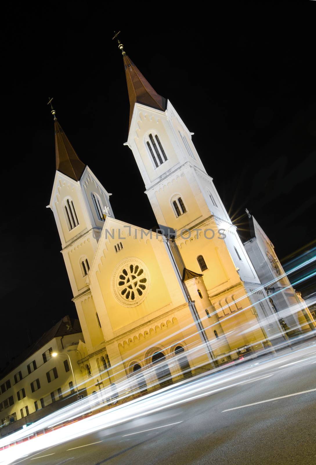 Czech christian church at night with car light lines in fornt.