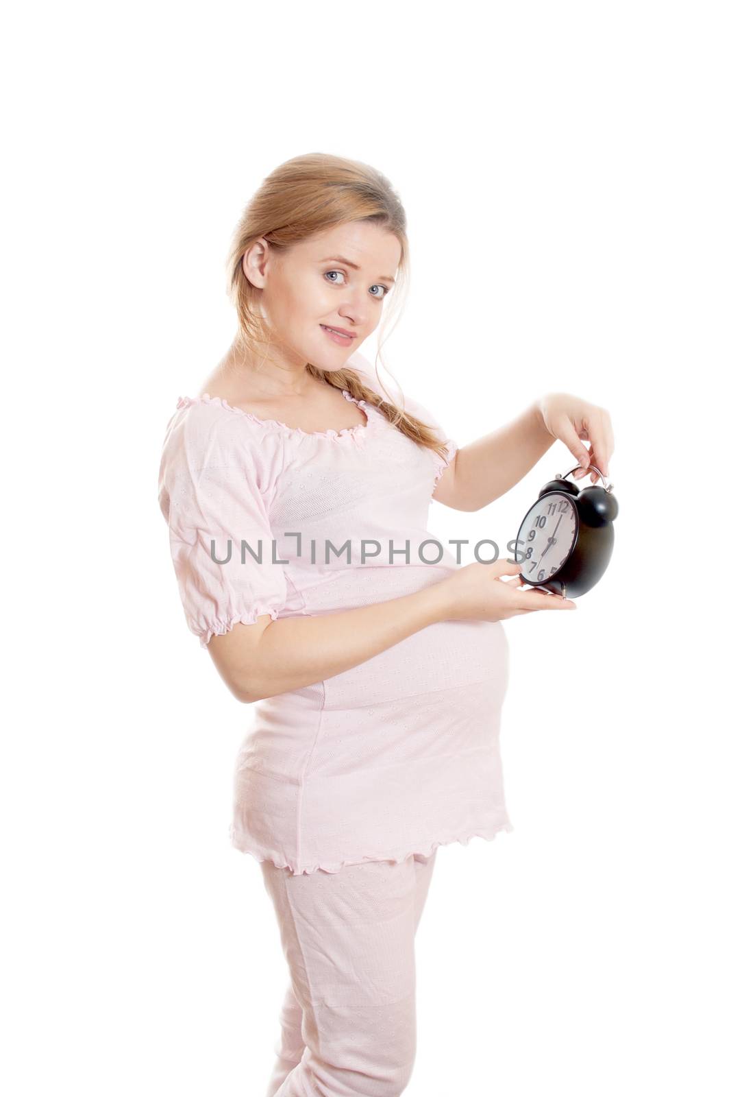 Pregnant woman looks at the clock on a white background