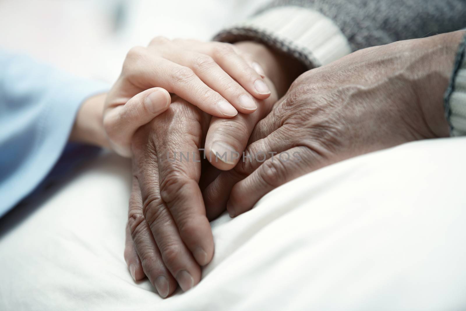 Hand of woman touching senior man in clinic