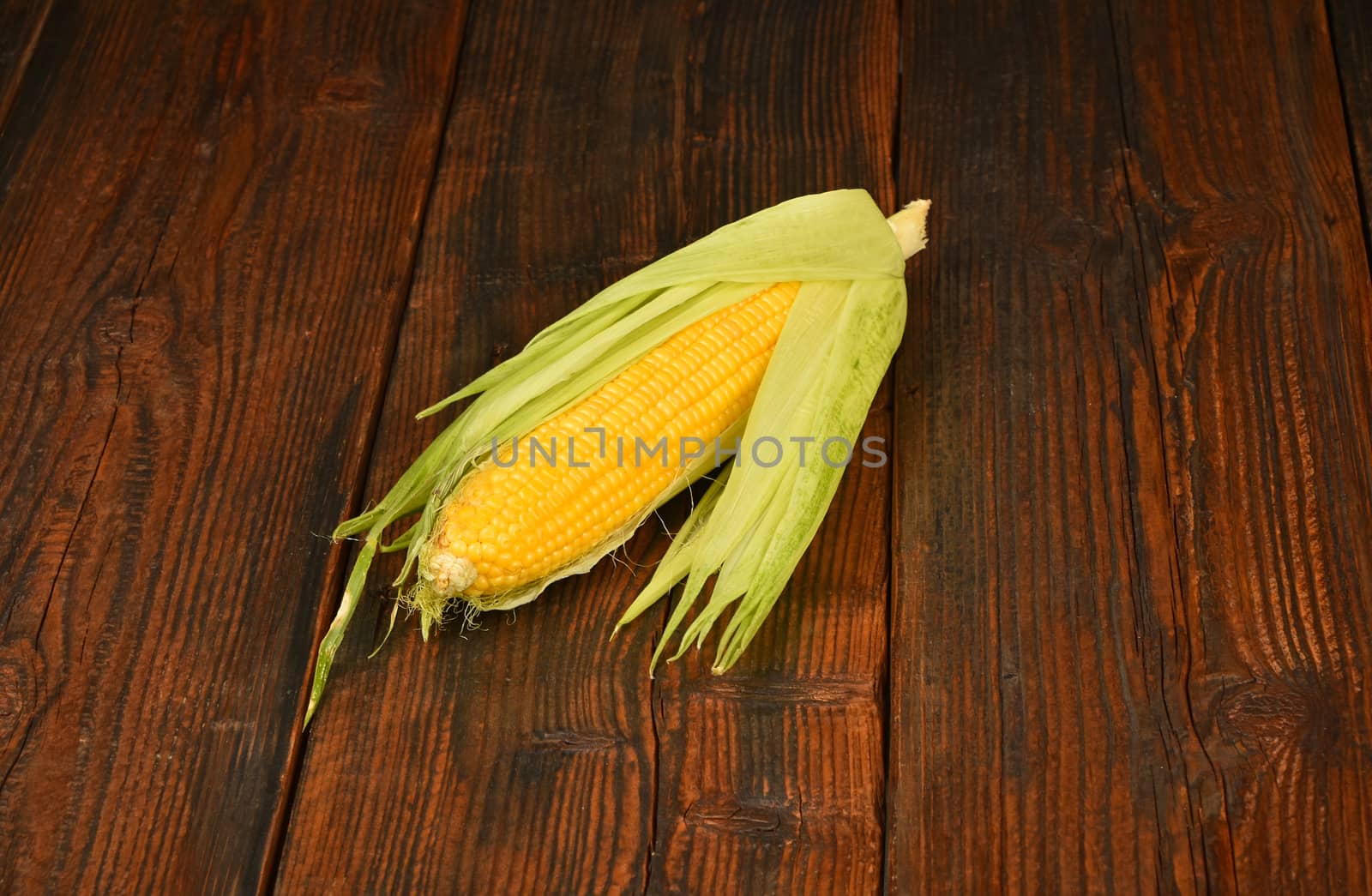 One open corn cob on vintage wooden surface by BreakingTheWalls