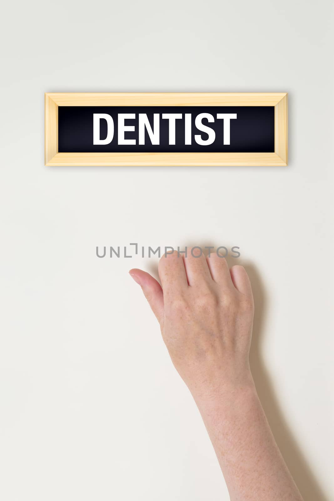 Female hand is knocking on Dentist door by stevanovicigor