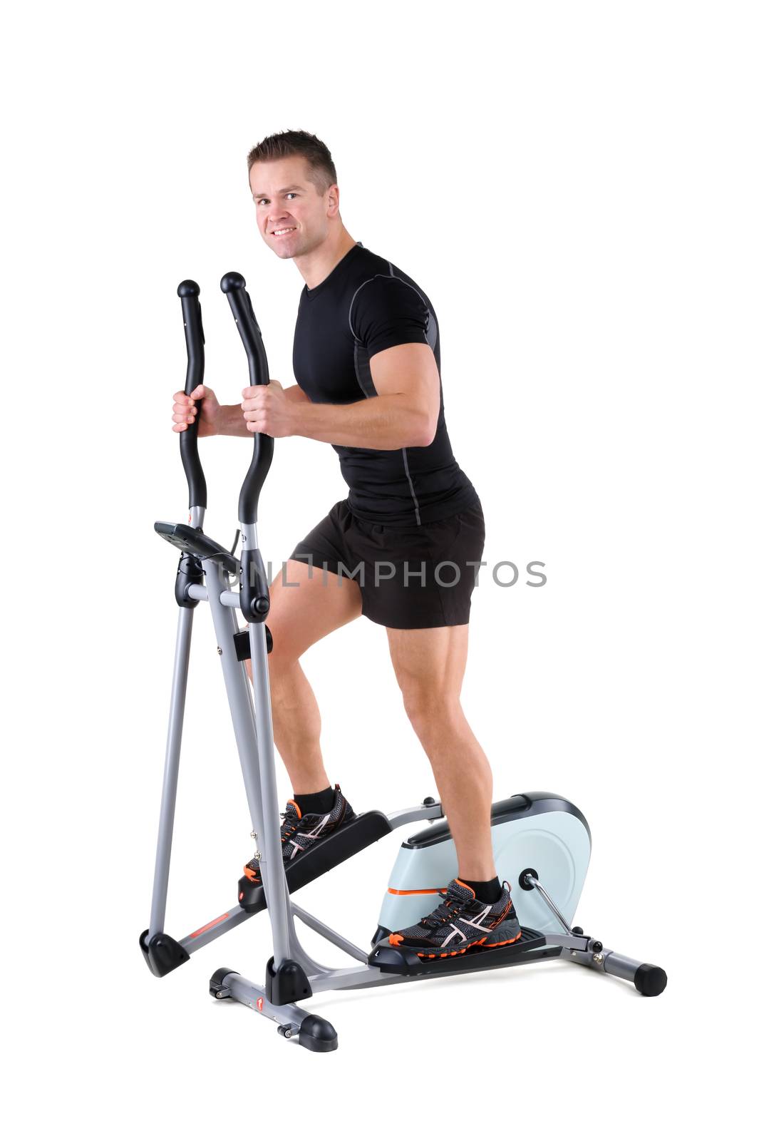young man doing exercises on elliptical trainer by starush