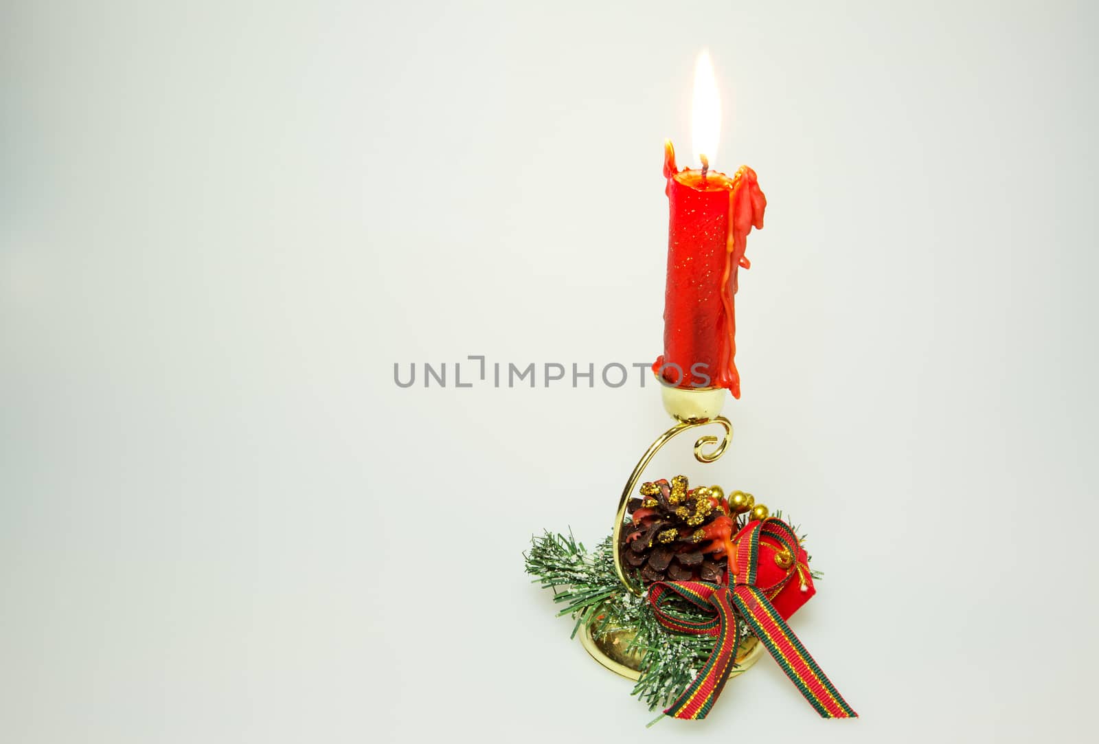 Christmas decoration with of the cone, green branches, ribbons and red candle, isolated on a white background.Horizontal view.