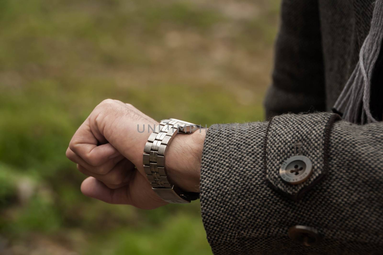 the man looks at her mechanical watch. Closeup of watch and the hand