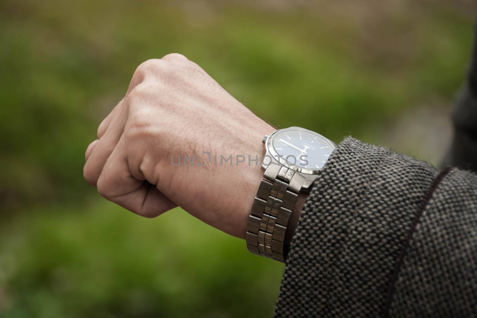 the man looks at her mechanical watch. Closeup of watch and the hand