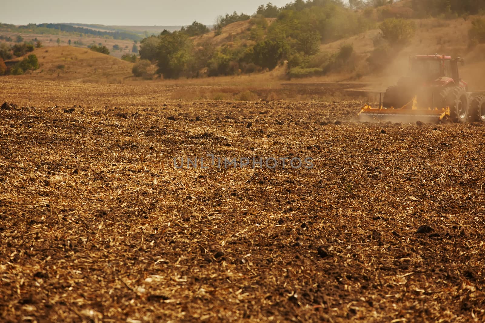 Agricultural Landscape. Tractor working on the field. Spring sunny day