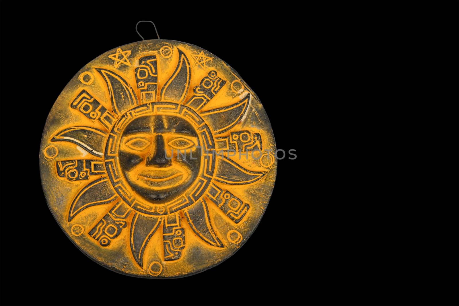 Mexican traditional yellow ceramic sun symbol plate souvenir isolated on black background