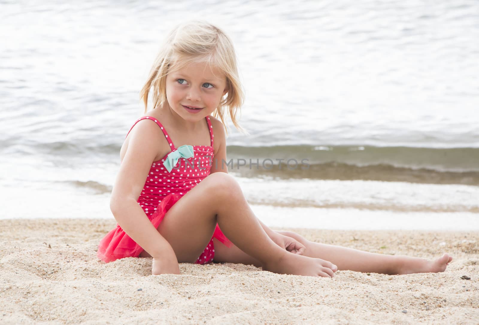 Little Girl Sunbathing on the Beach by gregorydean