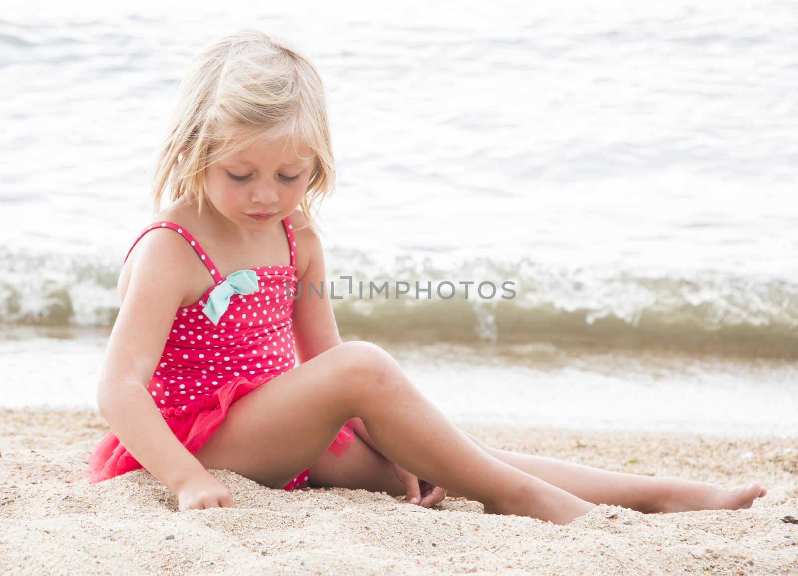 Little Girl Sunbathing on the Beach by gregorydean