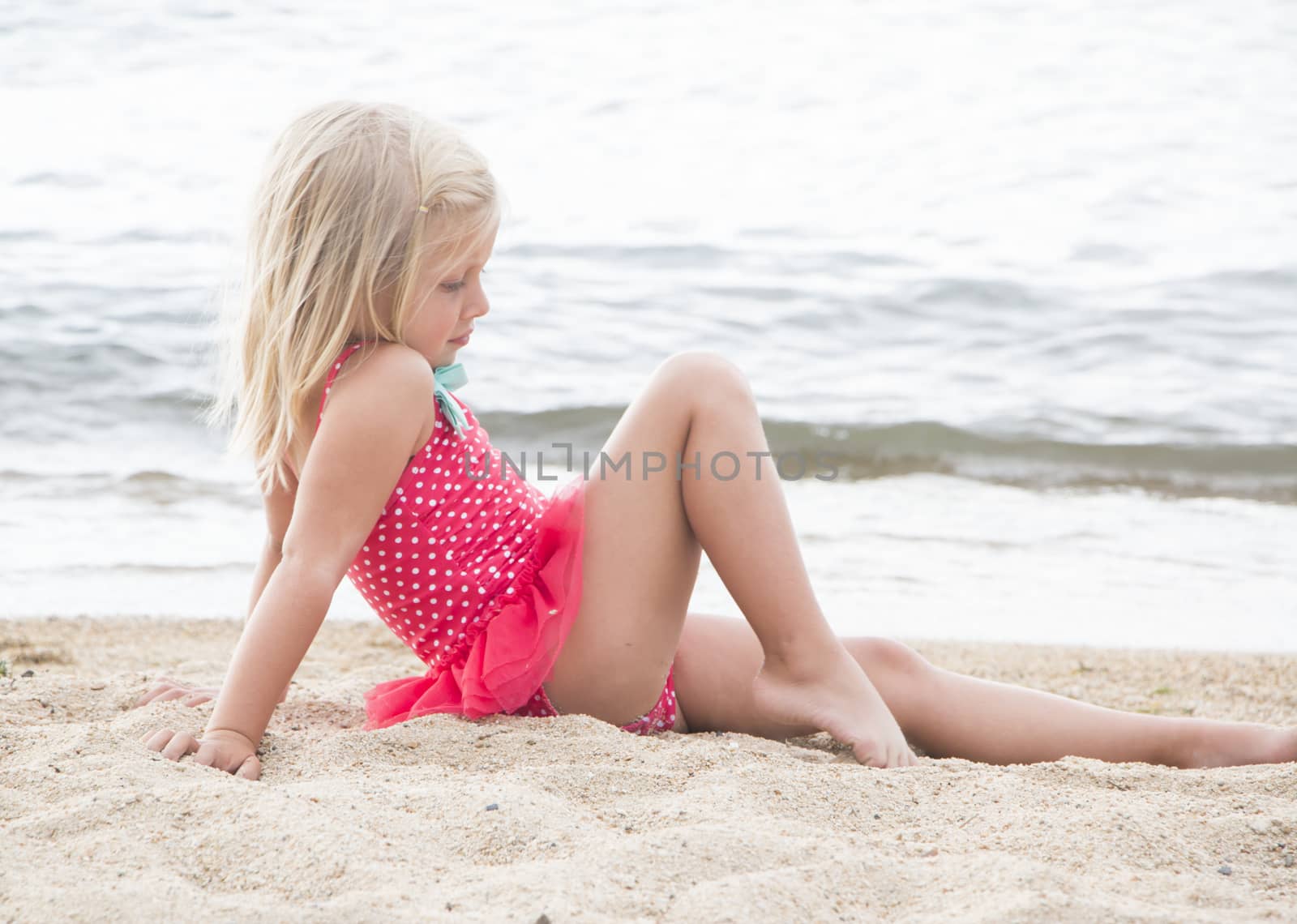 Cute Little Girl Sunbathing on the Beach