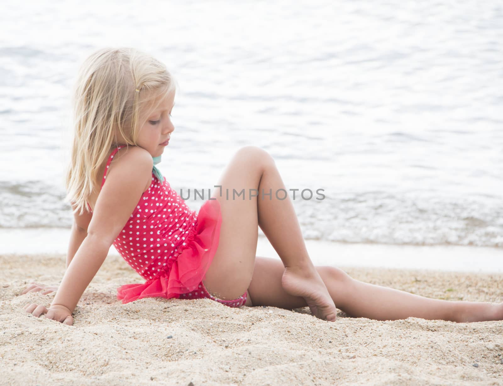 Little Girl Sunbathing on the Beach by gregorydean