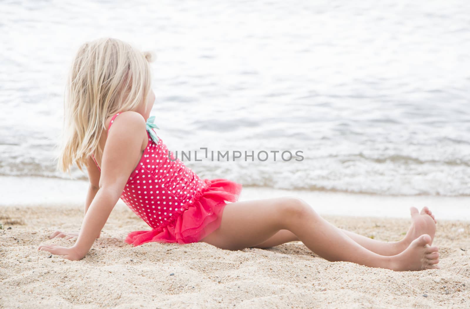 Little Girl Sunbathing on the Beach by gregorydean
