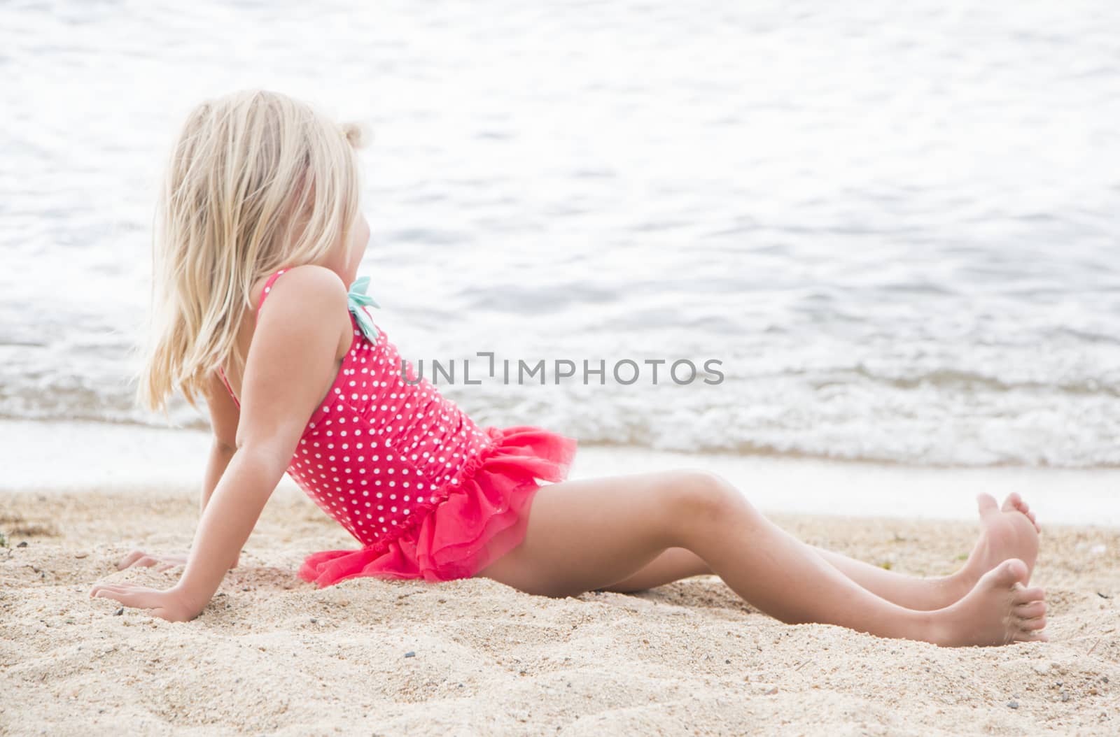 Cute Little Girl Sunbathing on the Beach