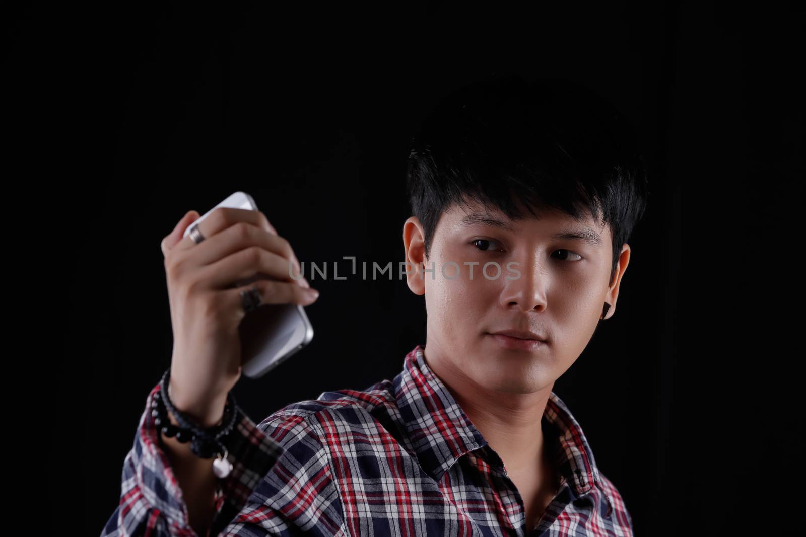 Portrait of Asian young man on black background