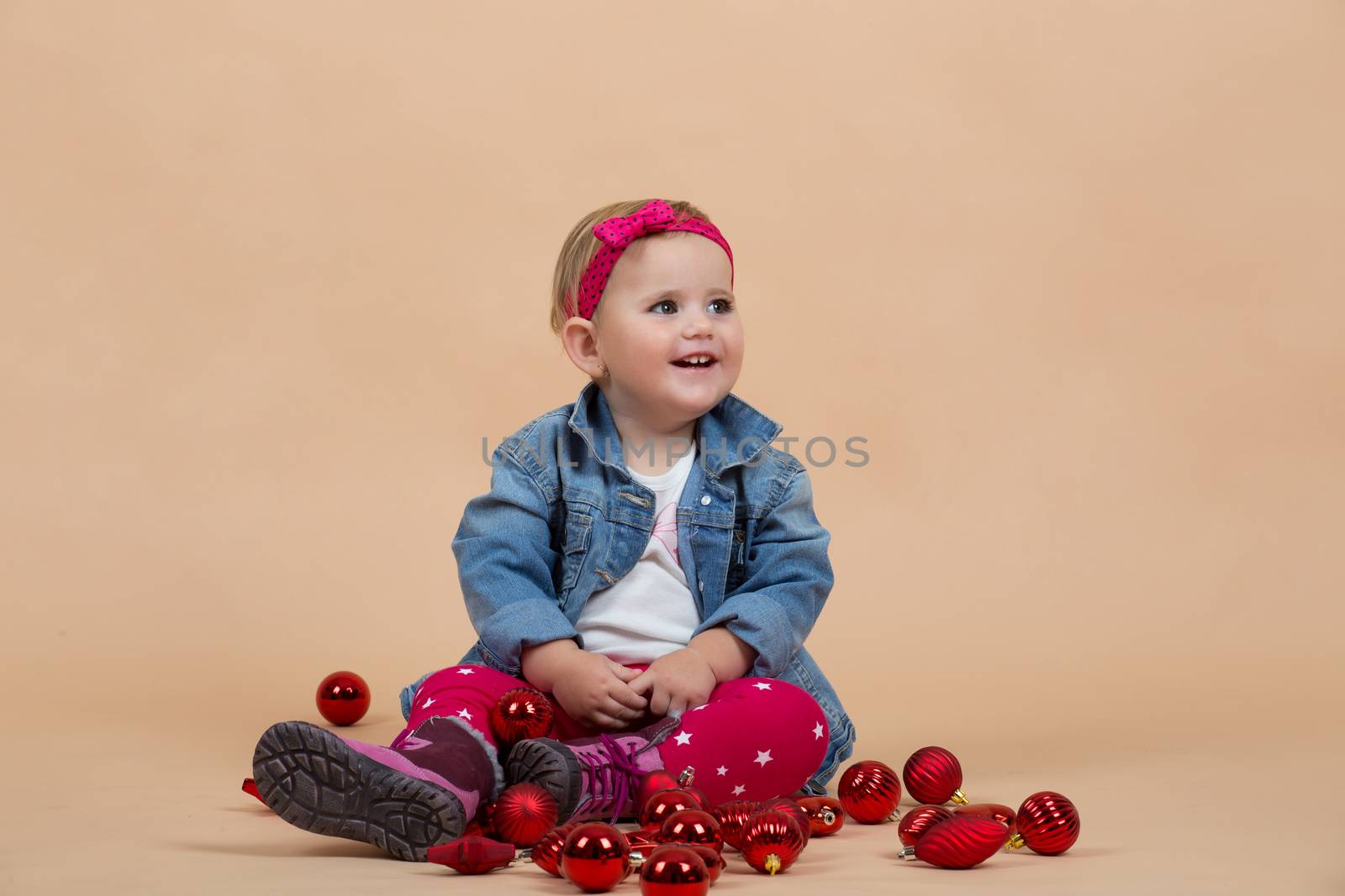 portrait of young cute baby on beige background with christmas balls portrait of young cute baby on beige background