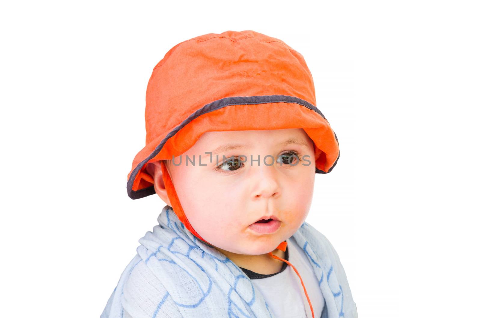 Baby with orange cap looking amazed. Background isolated.