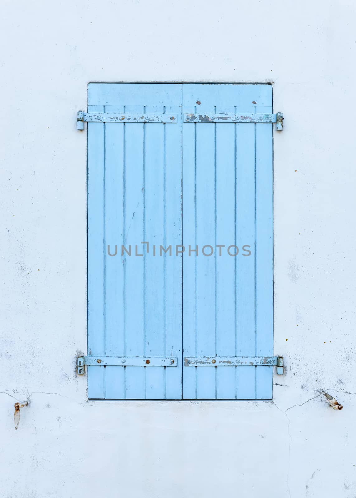 Closed blue wooden shutters, white wall