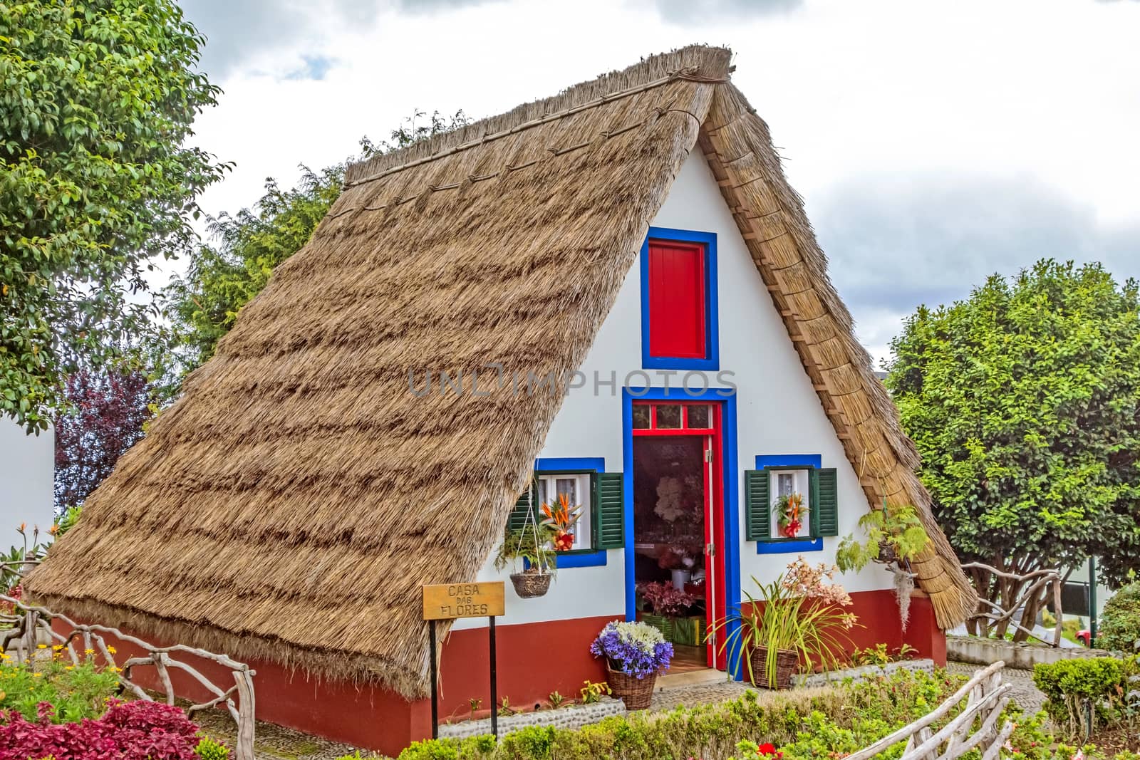 Santana, Portugal - June 7, 2013: Flower's related craft souvenir shop built like a typical triangular house, Island of Madeira.