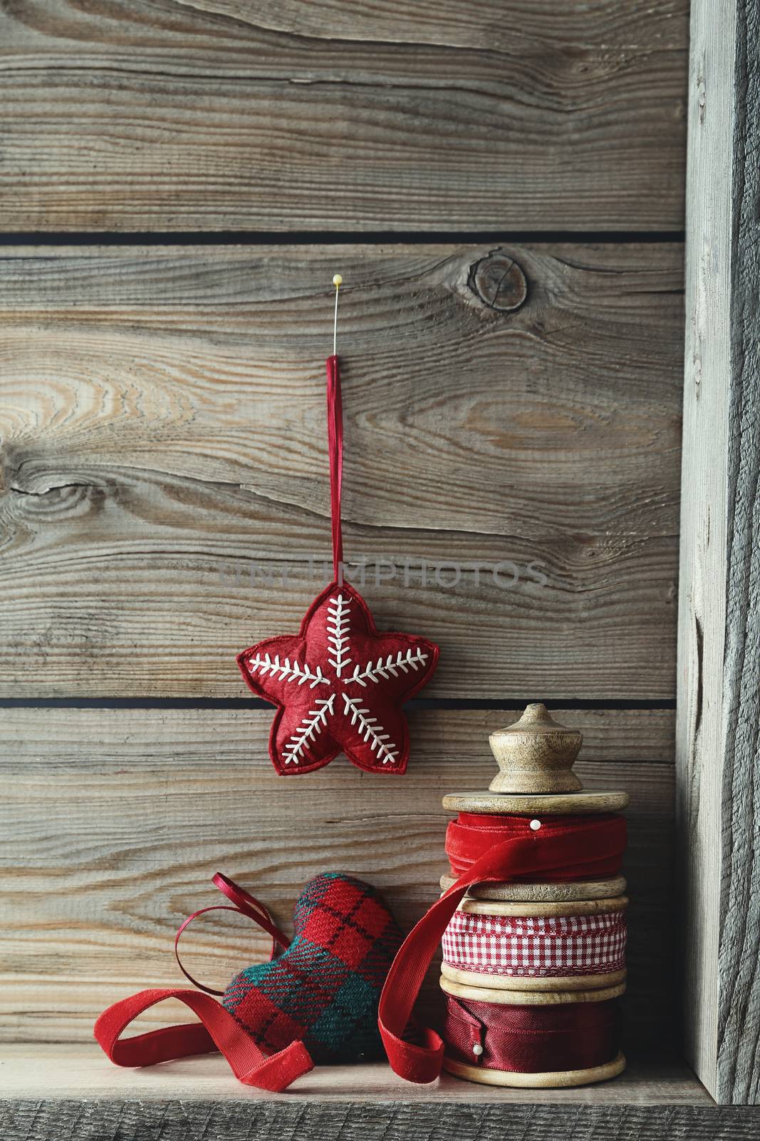 Ribbons and Christmas ornaments on wood shelf by Sandralise