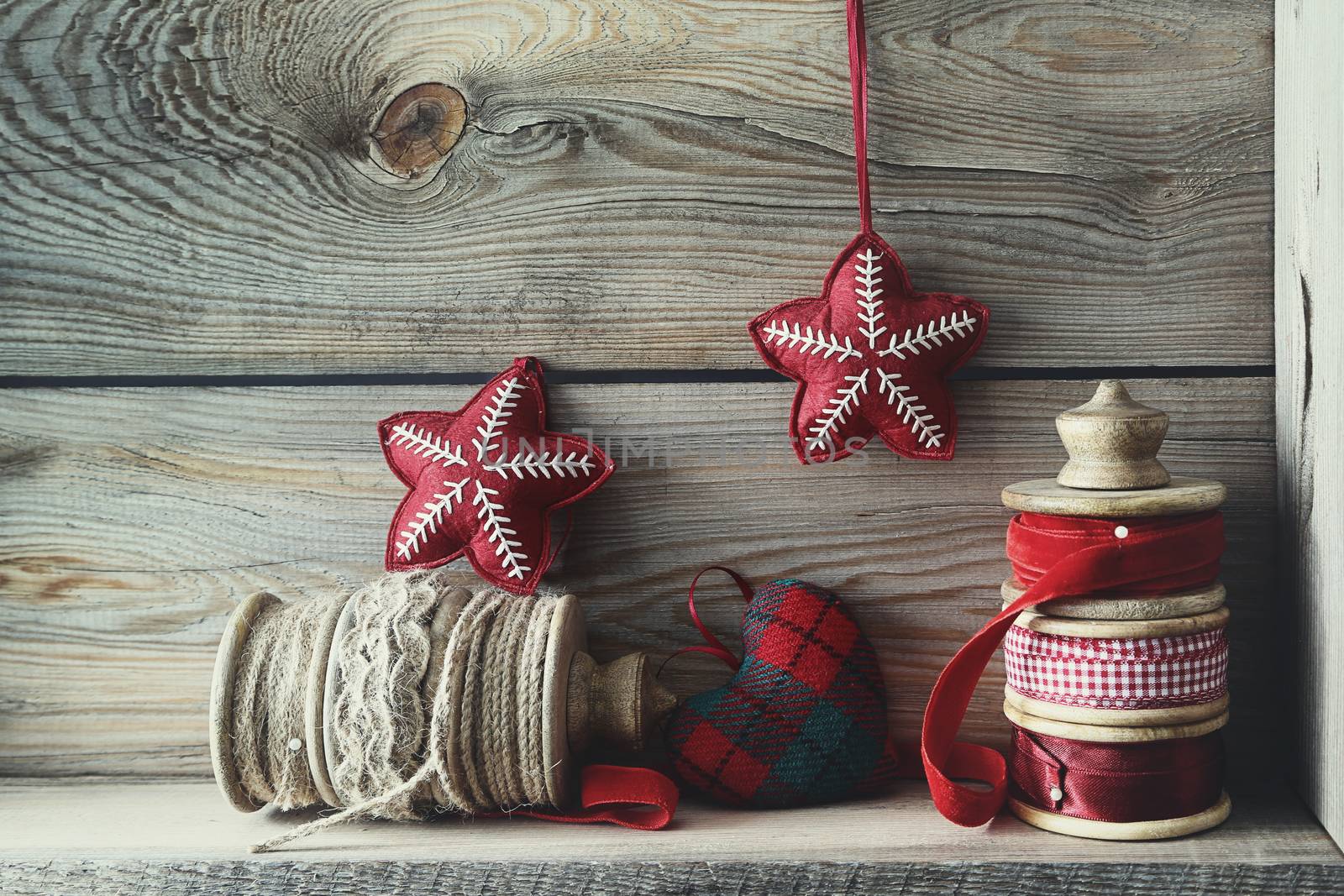 Ribbons and holiday ornaments on wood shelf by Sandralise