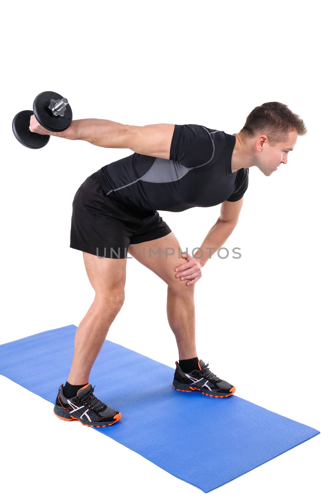 Young man shows finishing position of Standing Tricep Dumbbell Kickback workout, isolated on white