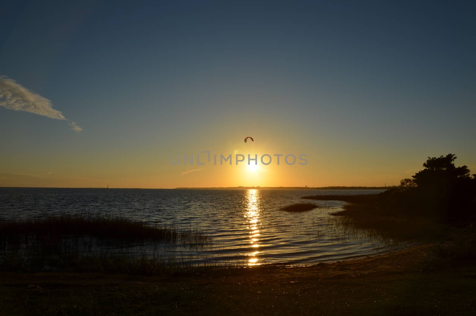 A wind surfer catching the last rays of sun over the water in North Carolina near Fort Fisher.