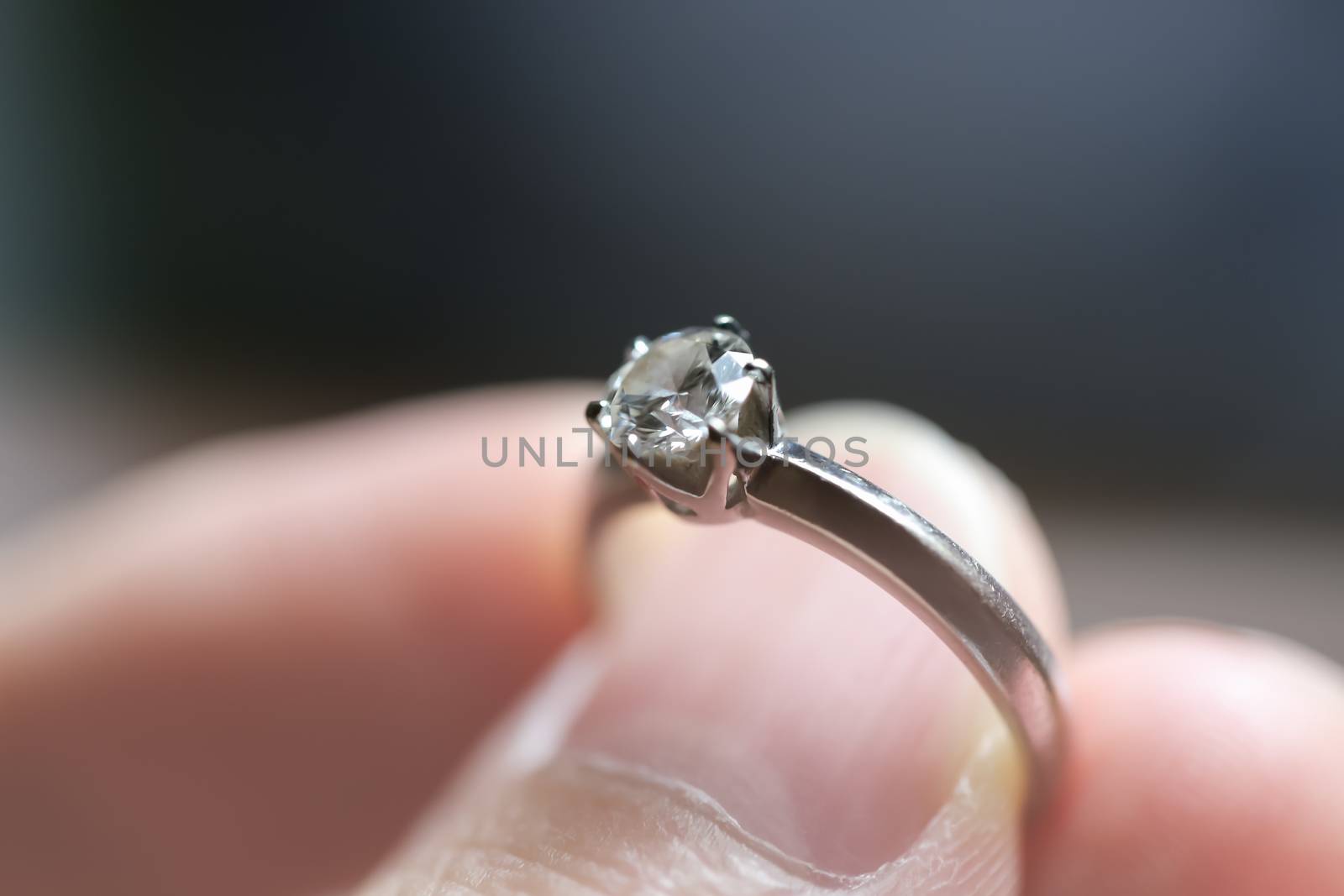 Diamond ring was holding by thumb and finger