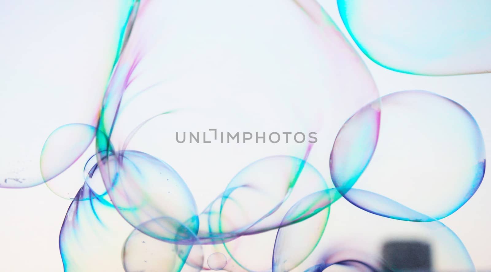 Soap bubbles on a blue sky illuminated by the sun texture background with copyspace