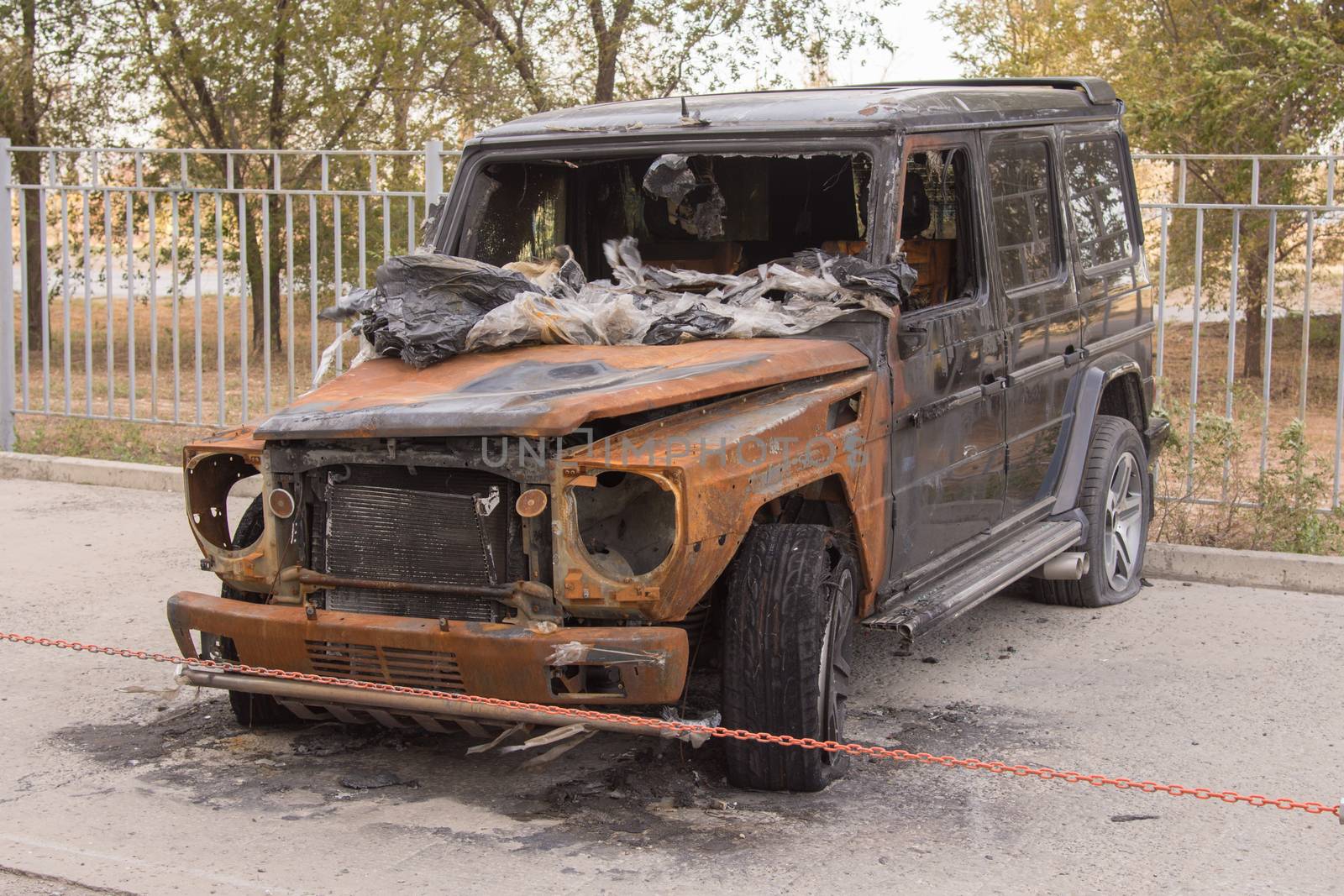 Burnt expensive SUV stands alone in the parking lot
