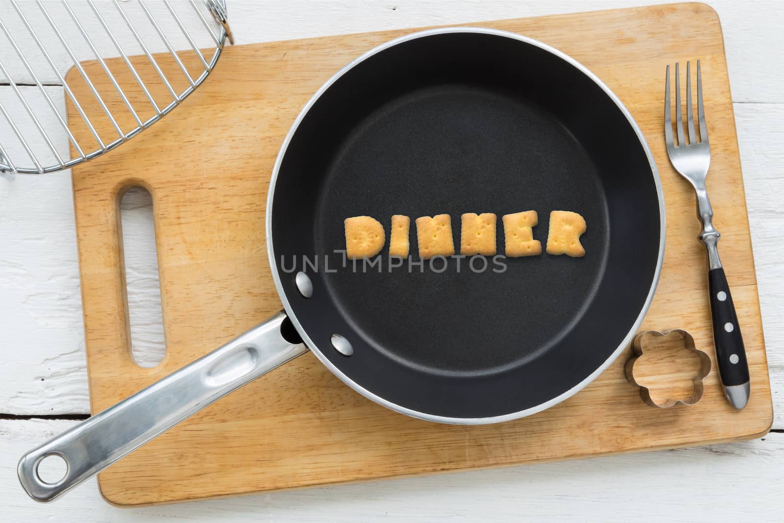 Alphabet crackers word DINNER putting in pan by vinnstock