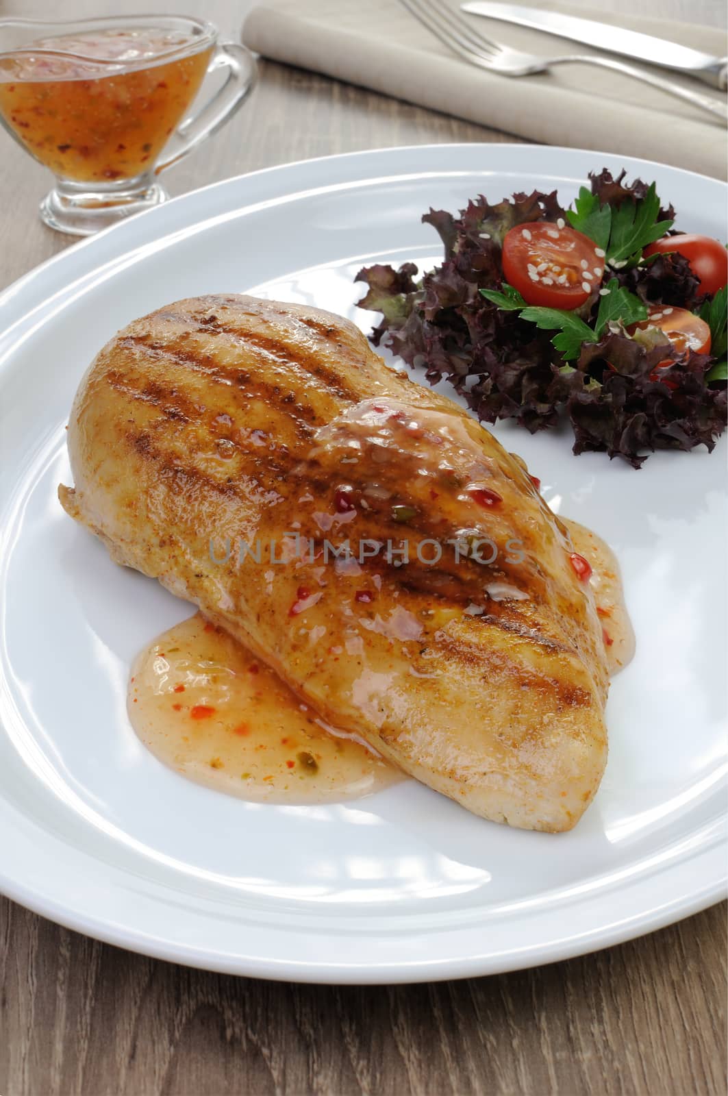 Chicken breast with sweet and sour sauce salad garnish on a plate