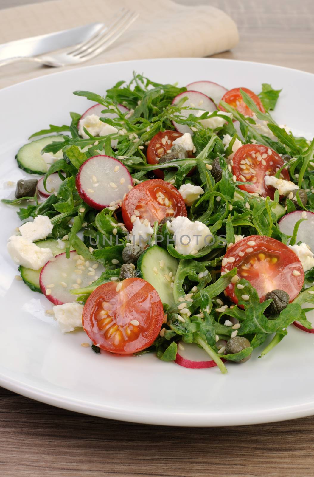 Vegetable salad with arugula, feta ,olive dressing and  sesame seeds