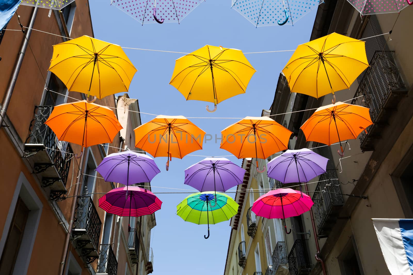 Colored parasols in the streets of Iglesias, Sardinia, Italy