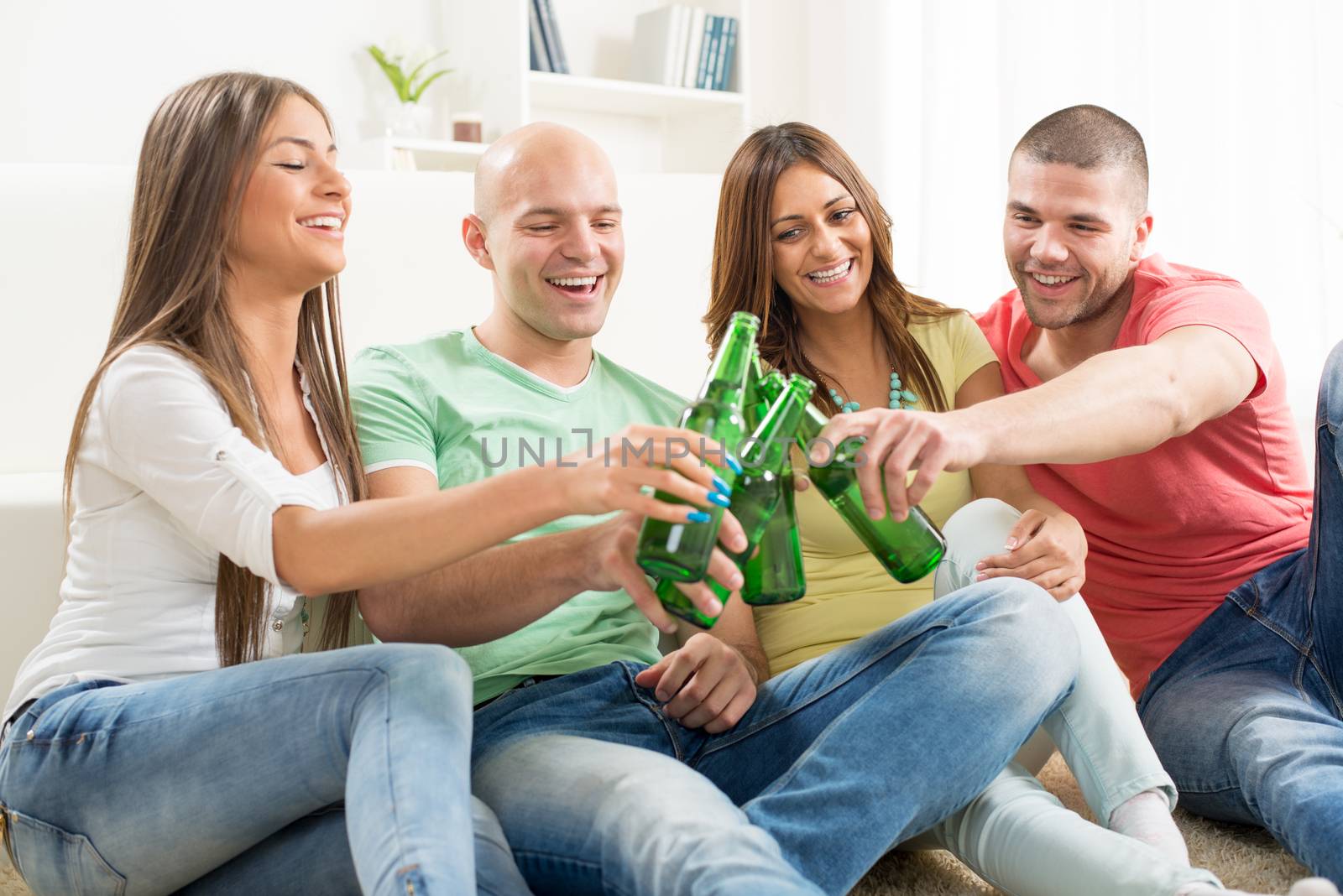 Friends enjoying with beer and cheers together at home party.