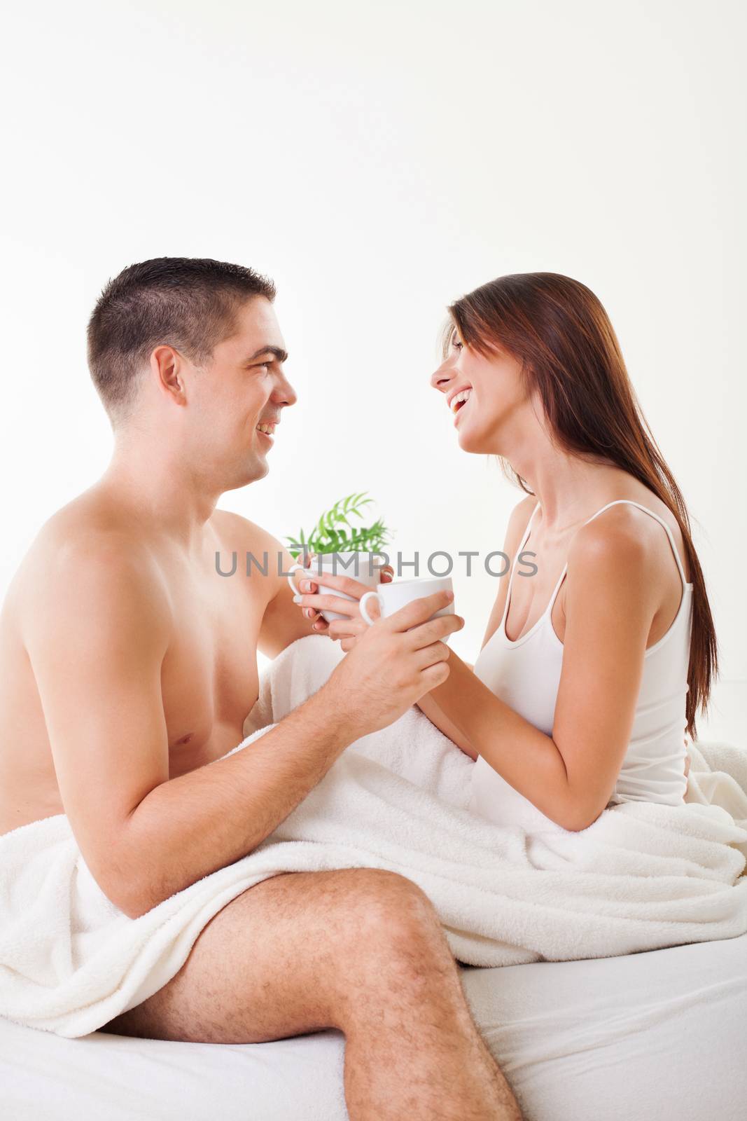 Romantic young couple drinking coffee for good morning in the bed.