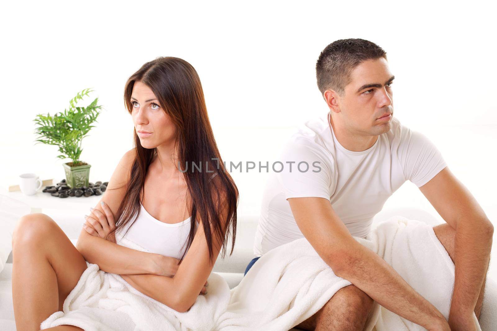 Angry Young couple sitting on the bed because of  Relationship Difficulties