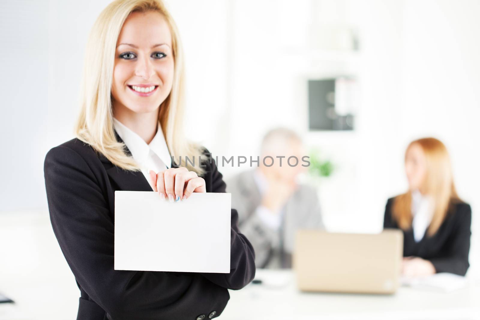 Beautiful young businesswoman holding Blank business card in the office. Looking at camera. Selective Focus.