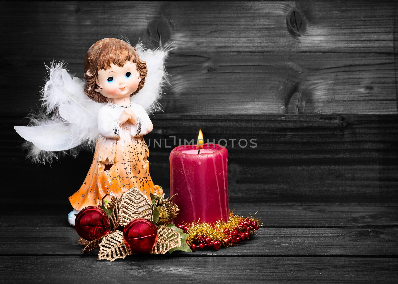 Christmas greeting card with candle and angels on wooden background black and white.