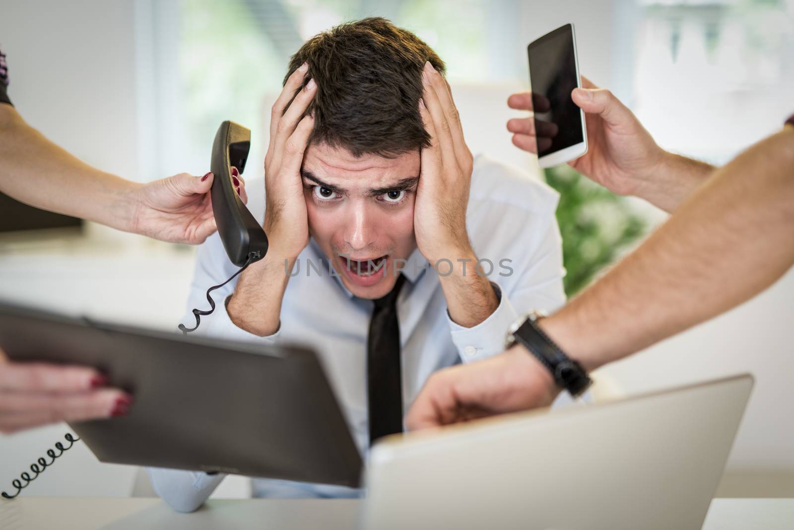 Stressed busineessman sorounded with many jobs.