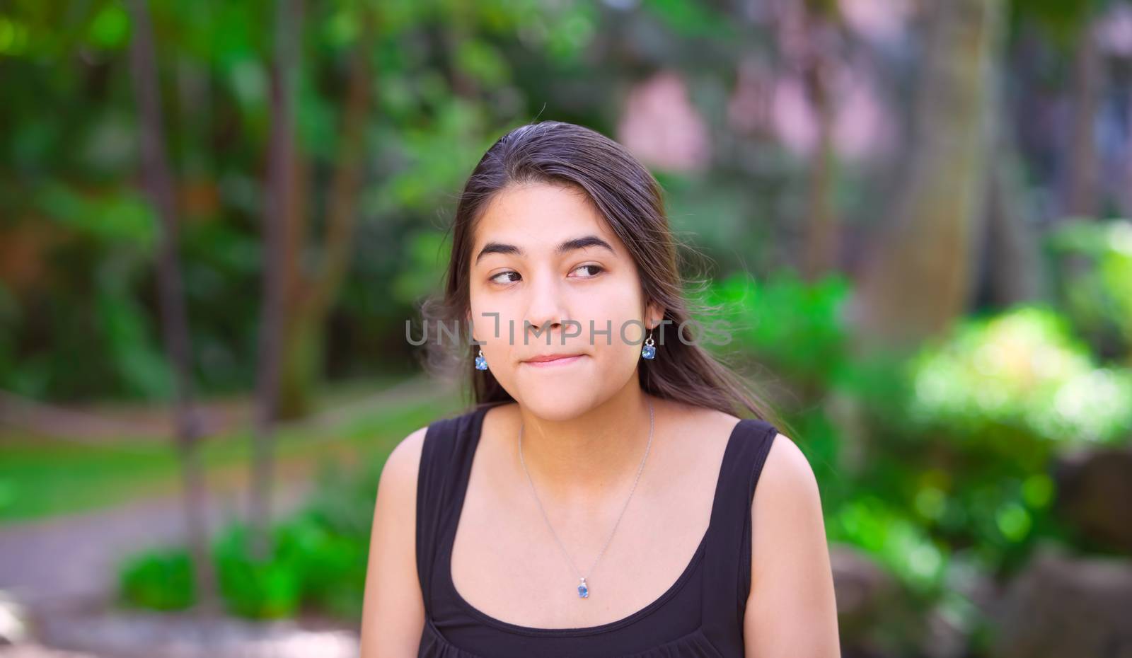 Biracial teen girl  outdoors making surprised expression off to  by jarenwicklund