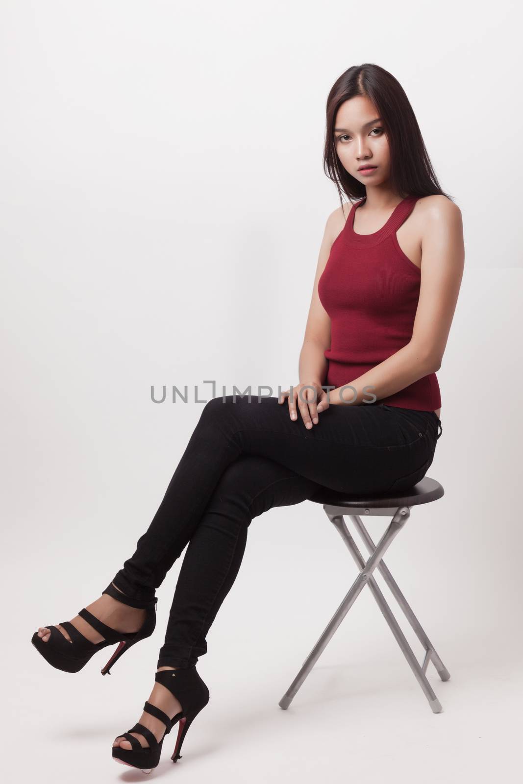 closeup fashion portrait of asian young sexy woman posing in studio. sit on chair