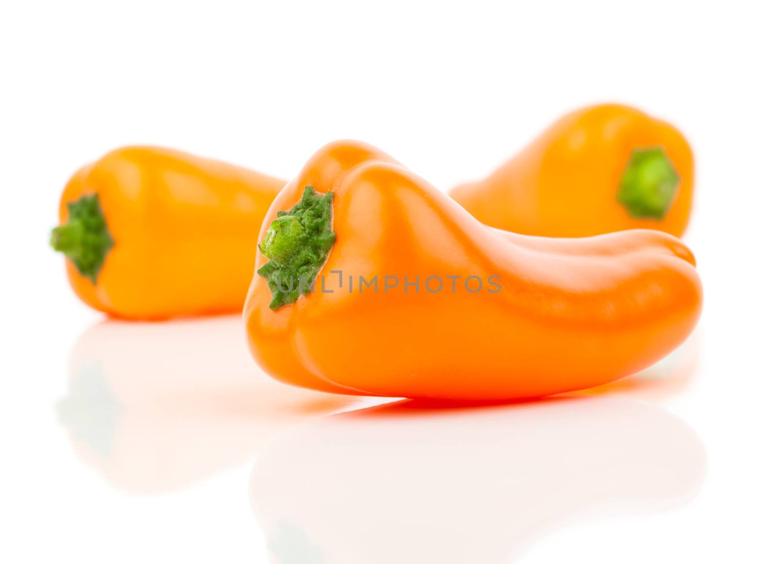 orange peppers (capsicum) on a white background by motorolka