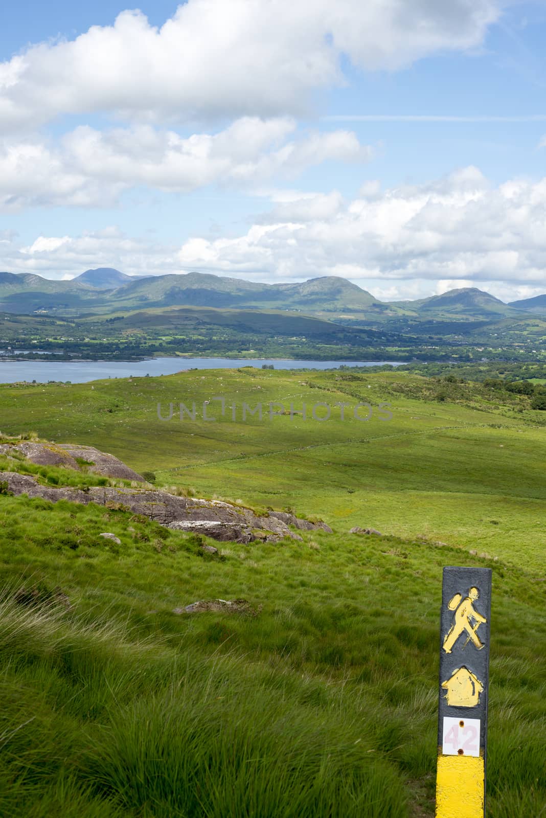 hiking signpost with mountain view by morrbyte