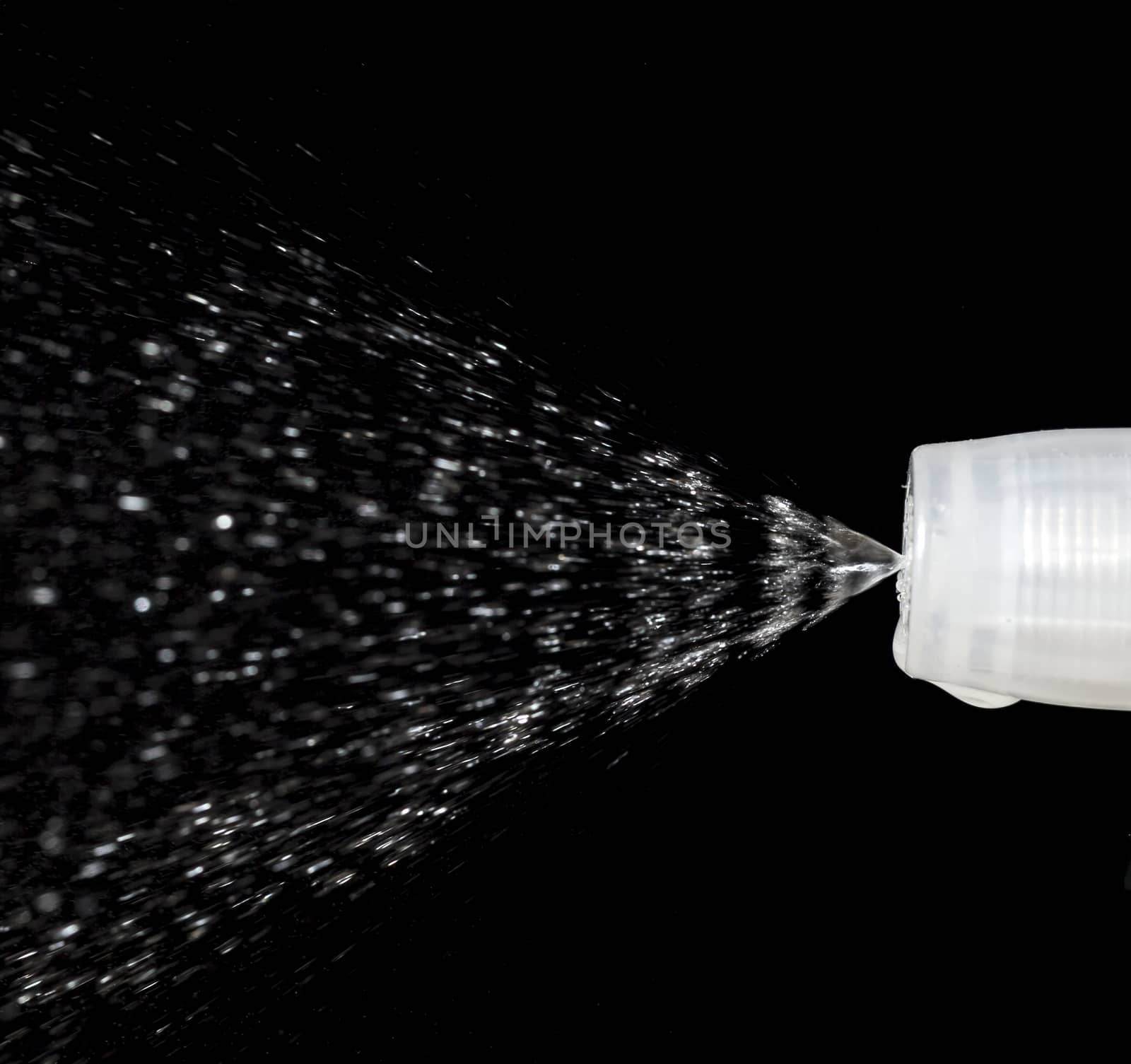 Water Spray Nozzle spraying water with a black background behind it.