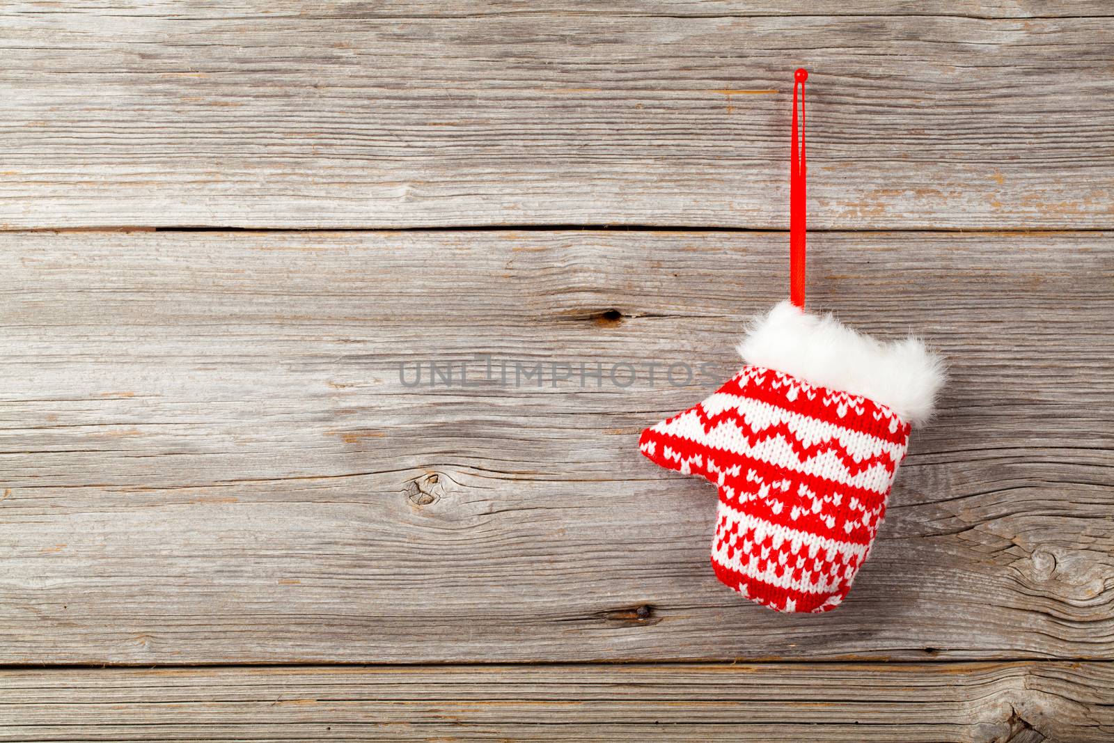Red mitten on wooden background by motorolka
