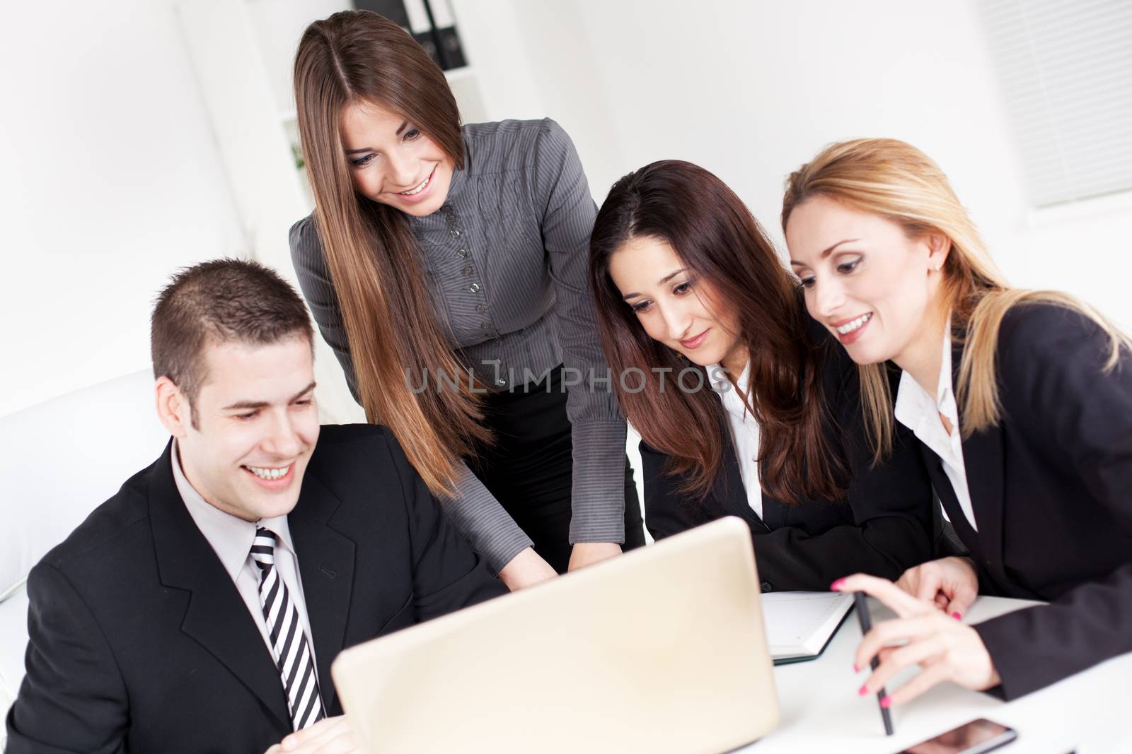 Happy Business woman showing her colleagues project at laptop in the office.